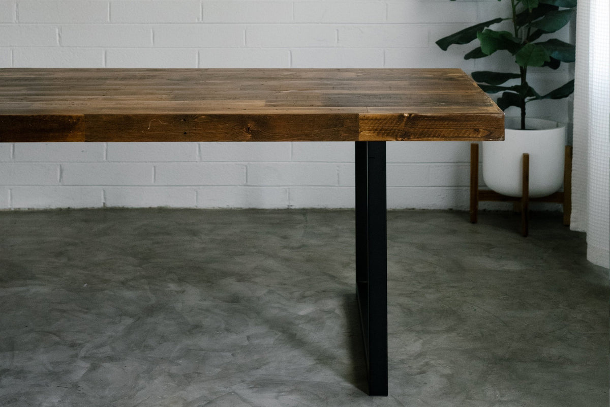Handcrafted in Arizona, this reclaimed wood dining table features a durable steel base and sleek black metal legs, embodying lasting quality. Perfect as a dining table or restaurant table for any modern industrial space.