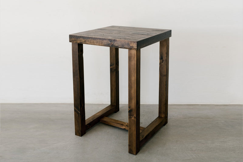 Handcrafted in Arizona, this square reclaimed wood bar-height table features a rich dark finish and minimalist open-frame design. Durable construction and sustainable materials make it an ideal counter or restaurant table.