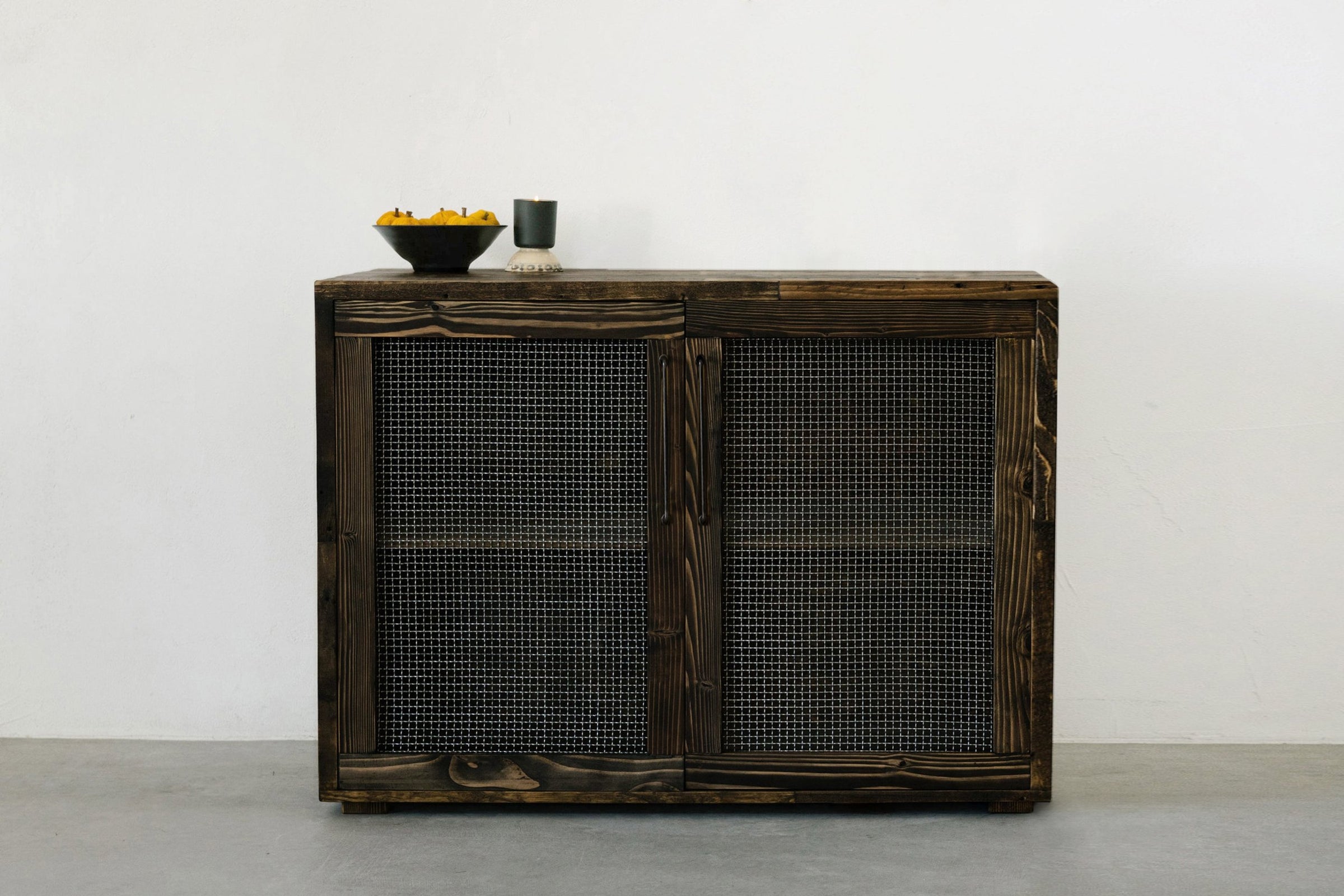Experience timeless design with this handcrafted reclaimed wood sideboard, featuring durable metal door insets. Perfect as a narrow bar table or kitchen island, it brings enduring quality and warmth to any space.