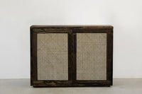 Expertly crafted sideboard features sliding doors with handwoven cane panels and a dark reclaimed wood frame. This durable, narrow piece adds sustainable elegance to any dining or restaurant space.