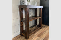 This handcrafted reclaimed wood bar cart features artisan-quality craftsmanship, a top shelf for glassware and decor, ample storage, and a wine glass rack. An ideal addition to kitchen islands or narrow bar-height tables.