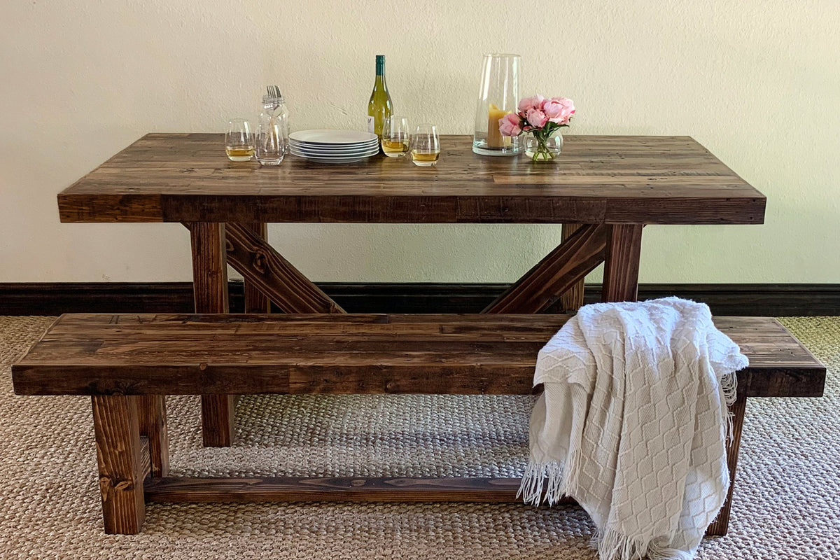 Handcrafted in Arizona, this reclaimed wood dining table with a matching bench showcases enduring quality and sustainable design. Set for entertaining, it highlights artisan craftsmanship in every detail—ideal as a kitchen island or restaurant table.