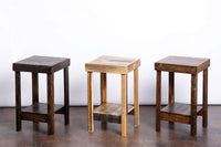 Expertly handcrafted in Arizona, these narrow reclaimed wood side tables—ideal as bar-height tables or accent pieces—feature square tops, lower shelves, and rich finishes, reflecting sustainable artistry and enduring quality.