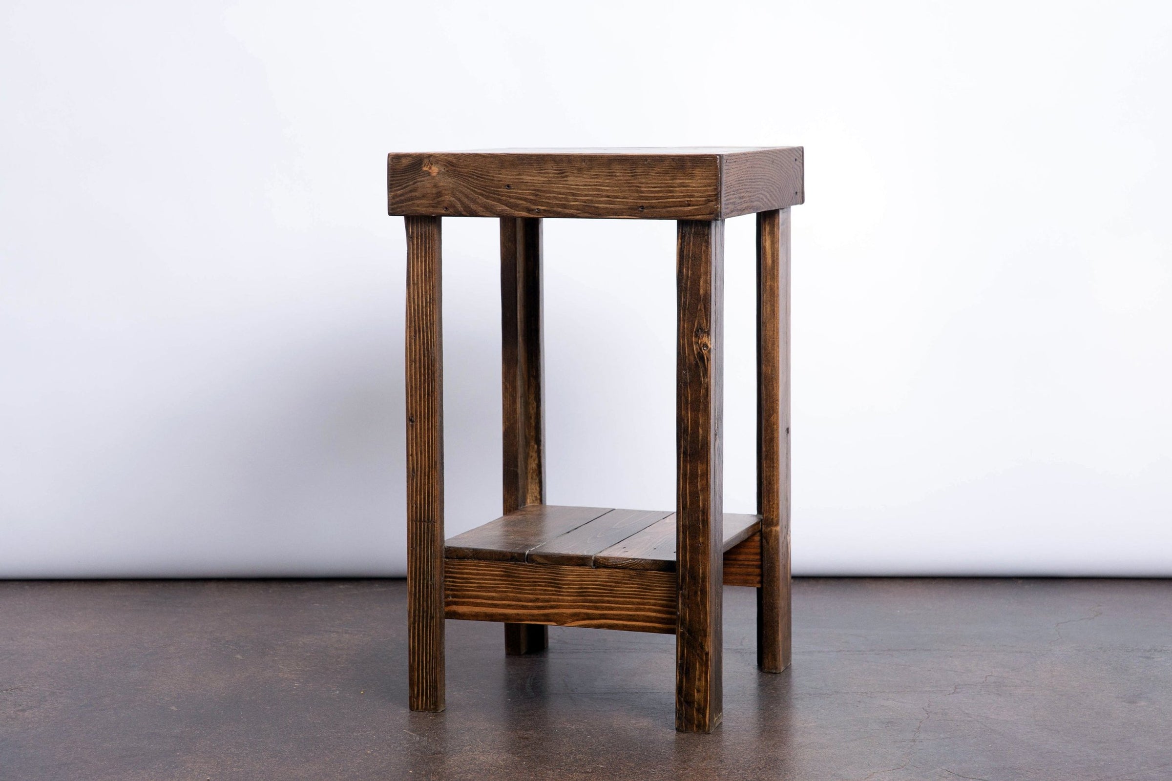 Handcrafted in Arizona, this narrow reclaimed wood side table showcases a rectangular top, four straight legs, and a functional lower shelf. A standout piece of sustainable reclaimed wood furniture for kitchens or small spaces.