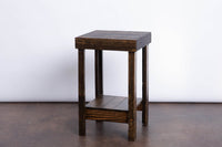 This handcrafted side table, built from sustainably sourced dark solid wood in Arizona, features four sturdy legs and a lower shelf. Ideal as a narrow bar-height table or reclaimed wood furniture accent for your kitchen or dining space.