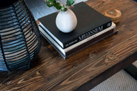 This handcrafted reclaimed wood coffee table showcases enduring quality, featuring a potted cactus, Arizona-themed books, a wooden container, and a woven lantern—perfect for homes seeking sustainable furniture design.