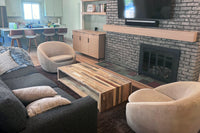 A cozy living room with a fireplace and television features a handcrafted reclaimed wood coffee table—showcasing Arizona-made craftsmanship and sustainable, enduring quality. Perfect as reclaimed wood furniture for style-forward homes.