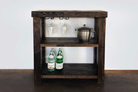 Handcrafted in Arizona, this artisanal bar cart features reclaimed wood and a sturdy steel base. Bar-height table design with hanging wine glasses, ice bucket, and storage for bottles—perfect for home or restaurant spaces.