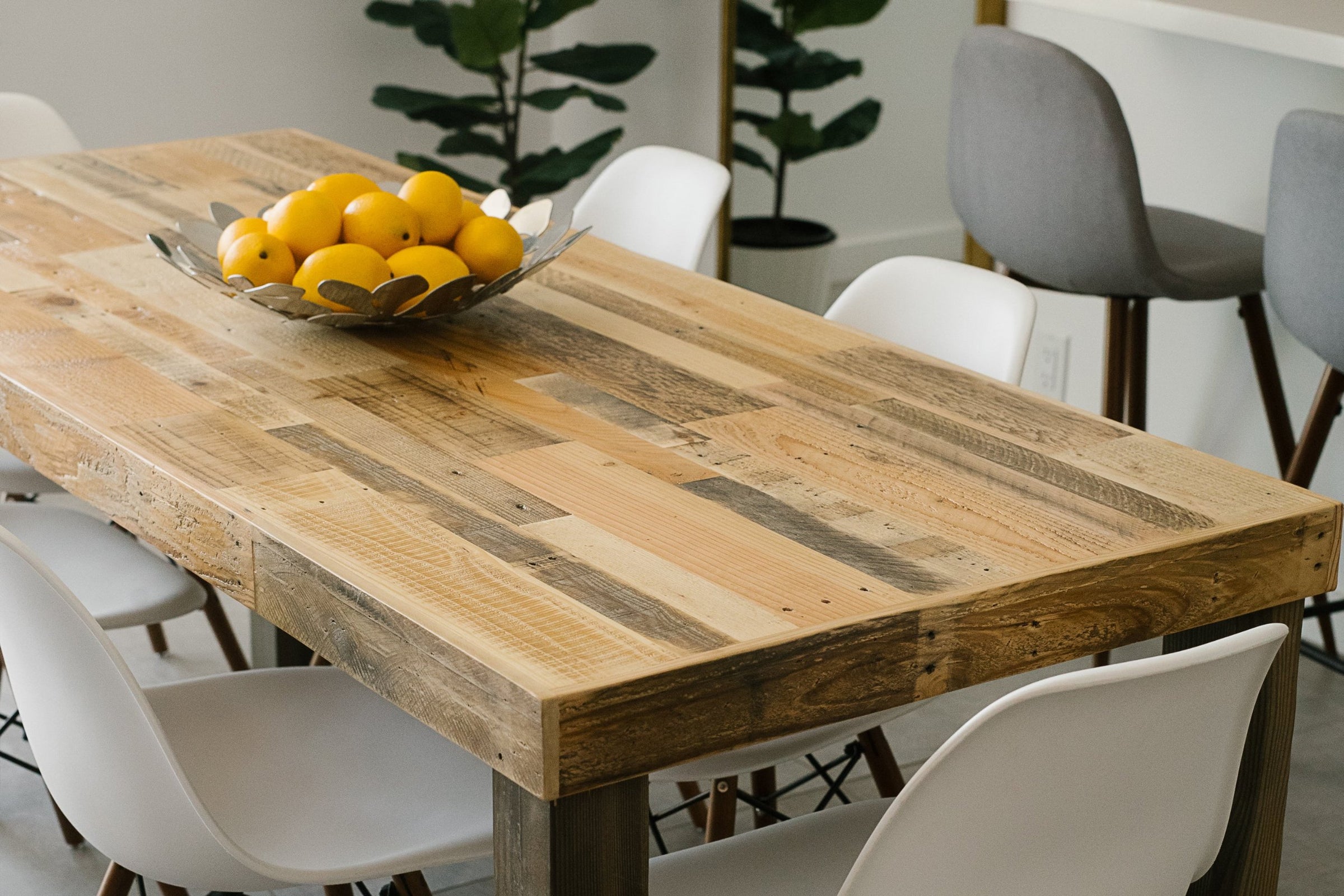 Experience enduring quality with this handcrafted reclaimed wood dining table, paired with sleek white chairs. Perfect as a restaurant table or centerpiece for the modern kitchen, it features sustainable materials and premium craftsmanship.