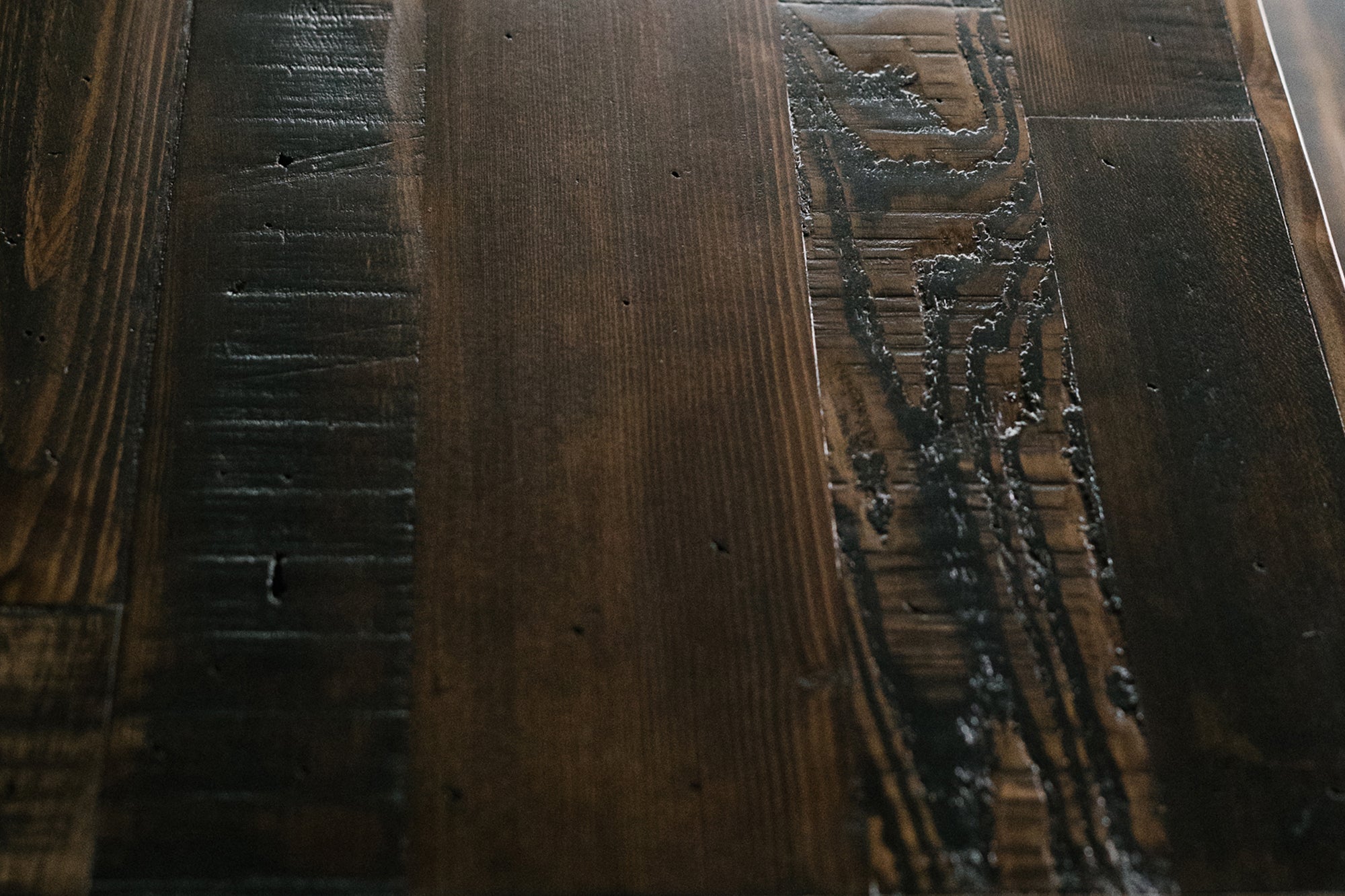 Close-up of handcrafted reclaimed wood, showcasing rich brown grain, natural scratches, and textured wear—ideal for a sustainable bar-height table or narrow kitchen island. Crafted with enduring quality in Arizona.