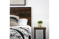 Experience enduring quality in this cozy bedroom, showcasing a bed with a handcrafted, rustic reclaimed wood headboard and a narrow nightstand crafted from sustainable materials, accented by premium textured bedding.