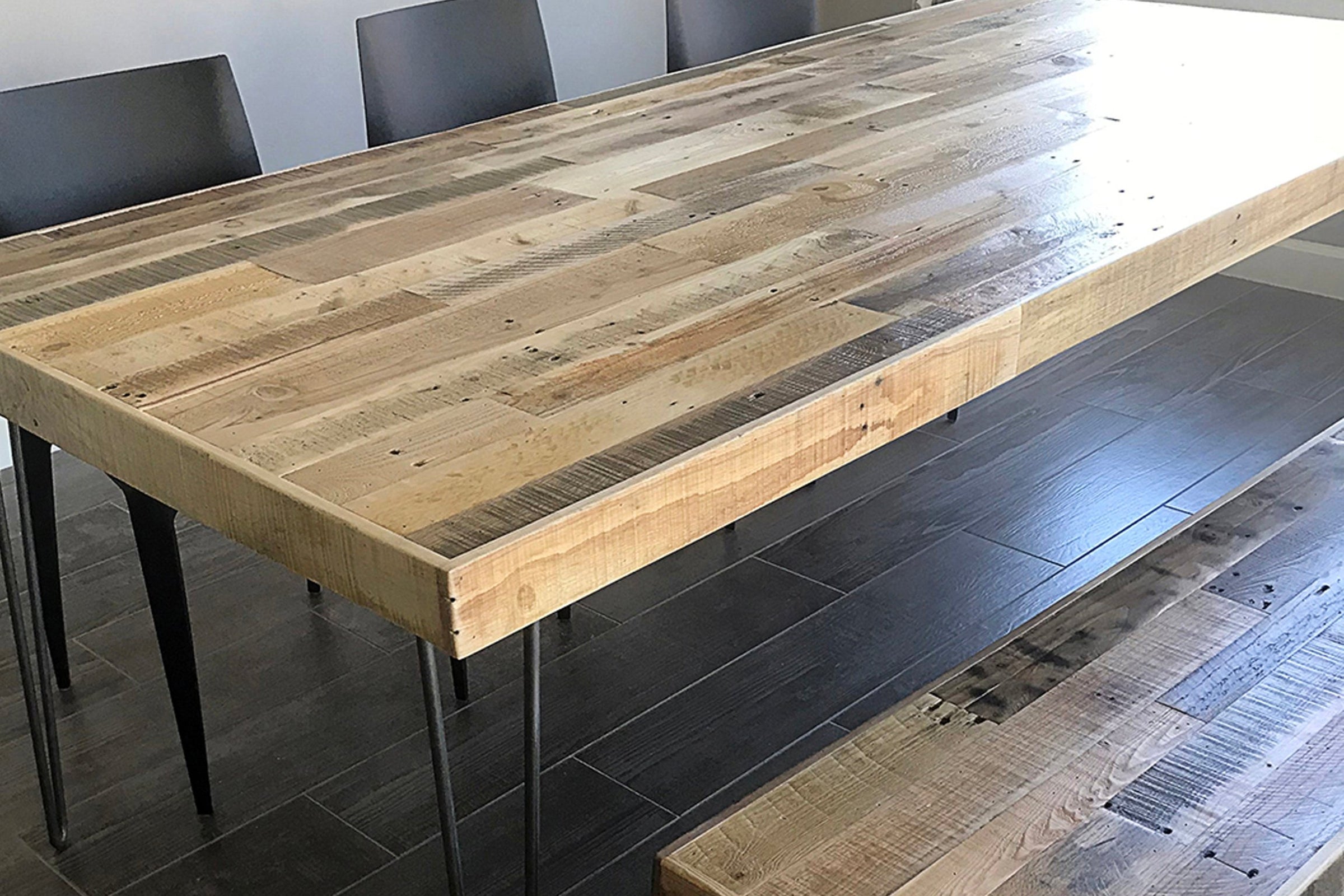 Experience the timeless beauty of a handcrafted reclaimed wood dining table, sustainably sourced and expertly finished with sleek black steel legs. Paired with modern black chairs and a matching bench, this Arizona-made table adds enduring quality and style to any dining space or restaurant setting.