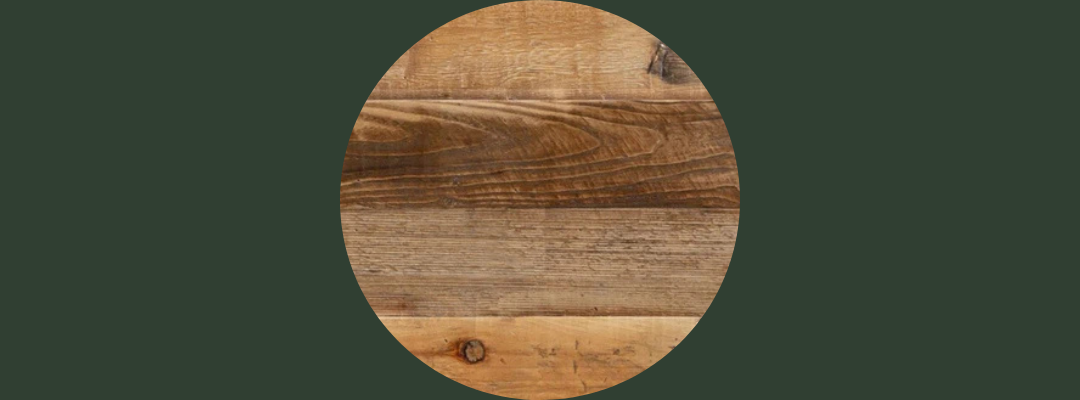 Round reclaimed wood tabletop with rich natural grain and multi-toned brown hues, ideal for bar-height dining tables in modern cafés or minimalist spaces; set against a dark green background.