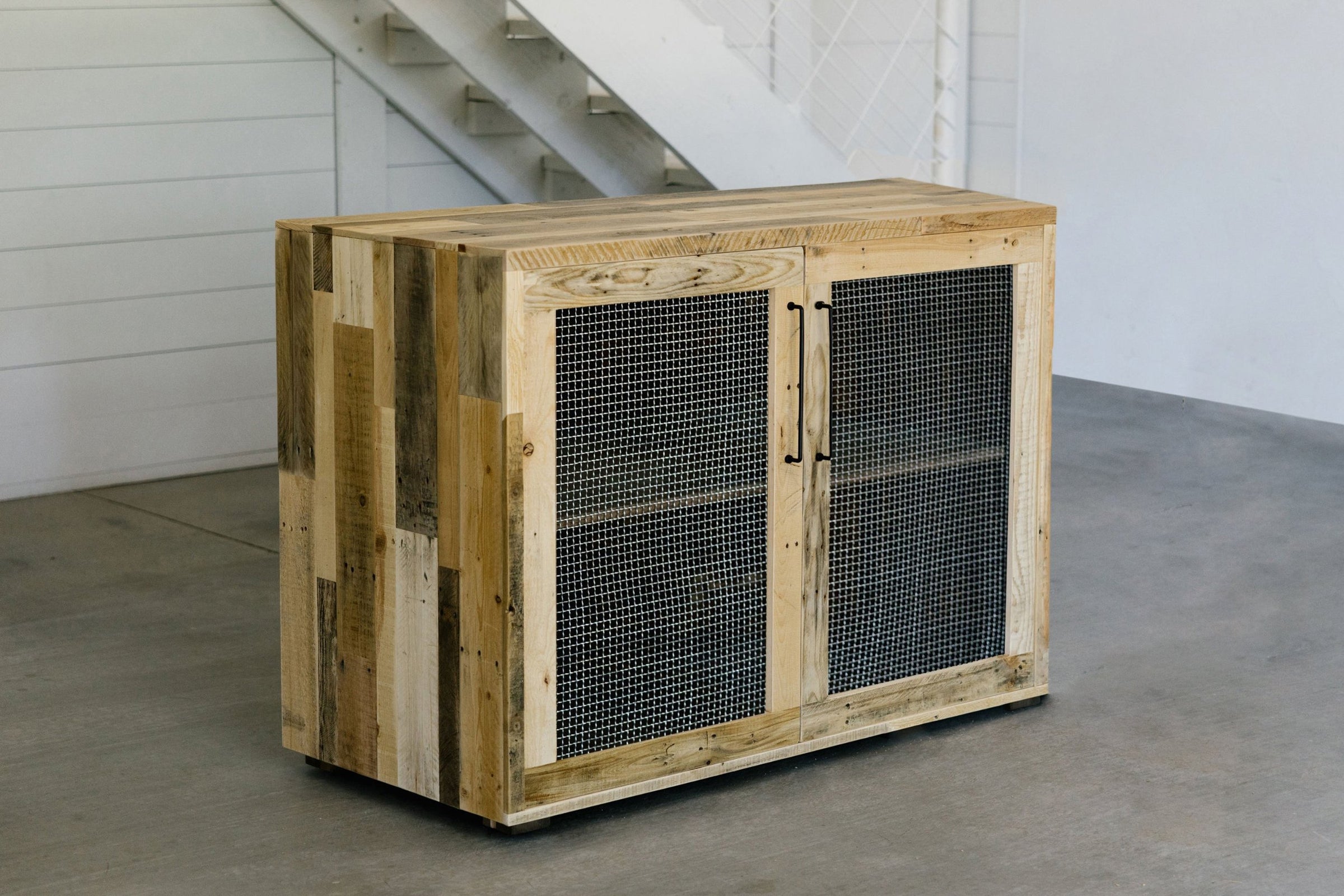 This handcrafted reclaimed wood sideboard features durable mesh wire doors and sleek black handles. Perfect for modern spaces, it’s a standout piece of sustainable reclaimed wood furniture built to last.