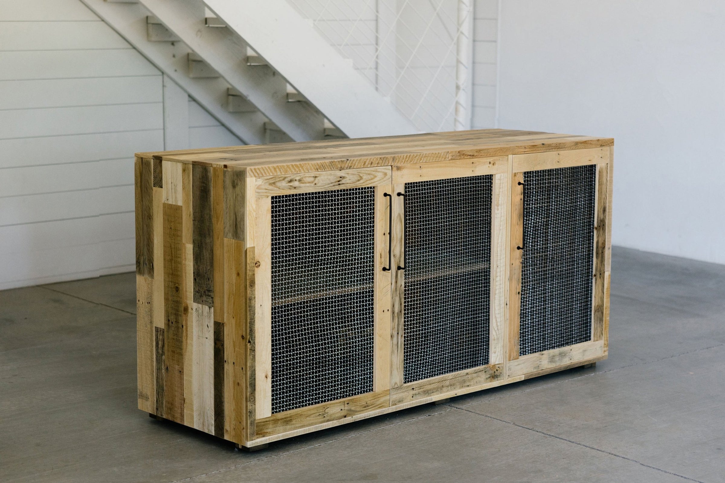 Handcrafted in Arizona, this reclaimed wood sideboard with three mesh metal doors brings lasting quality and artisan detail to any minimalist space—a versatile addition as a narrow table or bar table for the kitchen or dining area.