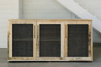 Handcrafted in Arizona, this reclaimed wood sideboard features four doors with black mesh panels and sleek vertical handles. Ideal as a narrow bar-height table or as reclaimed wood furniture for kitchens and dining spaces.
