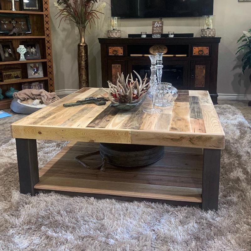 Square reclaimed wood coffee table featuring rustic craftsmanship and a rich natural grain, displayed on a beige textured rug with glassware and antler centerpiece; ideal for historic home or modern living room.