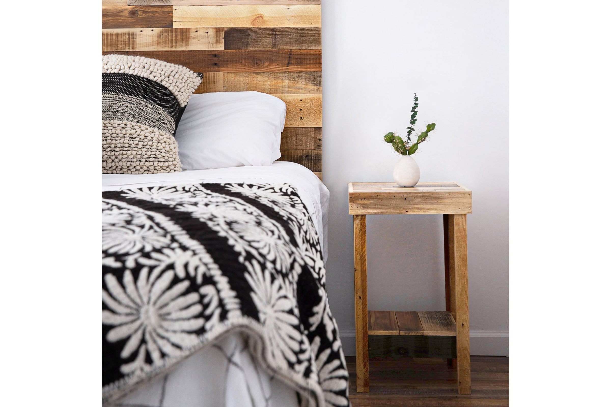 A welcoming bedroom features a handcrafted reclaimed wood nightstand, exemplifying Arizona artisanship. Paired with a sturdy wooden headboard, this reclaimed wood furniture piece elevates quality and sustainability.