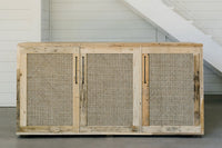 Expertly handcrafted in Arizona, this reclaimed wood sideboard features three cane door panels, offering enduring quality and sustainability. Ideal for dining or as a narrow bar table, it complements modern interiors beautifully.