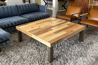 This handcrafted reclaimed wood coffee table, featuring a mixed plank top and robust dark legs, showcases artisan quality. Perfect as a living room centerpiece for sustainable décor and enduring style, on trend with reclaimed wood furniture.