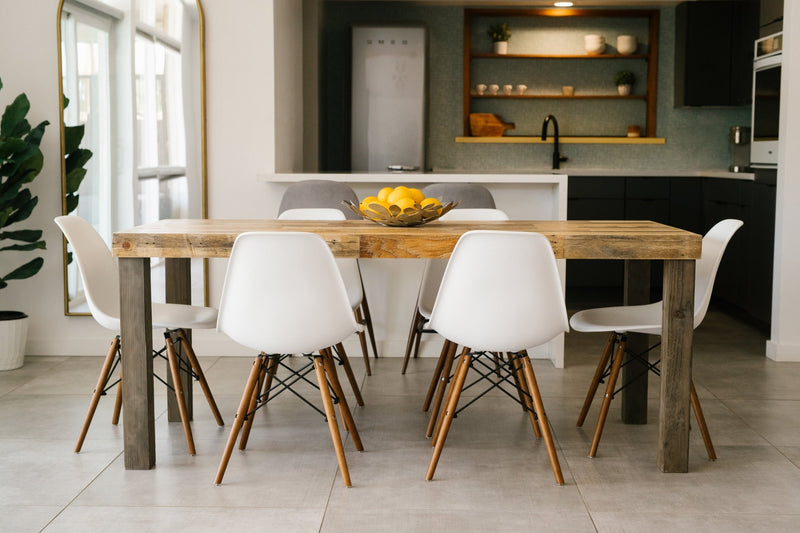 This inviting dining area showcases a handcrafted reclaimed wood dining table—expertly made in Arizona—paired with six white chairs. Sustainable materials and timeless craftsmanship reflect enduring quality, ideal for modern kitchens or restaurants.