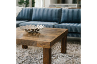 Experience timeless style with this handcrafted reclaimed wood coffee table, set atop a textured light gray rug before a blue upholstered sofa. Expertly made, this reclaimed wood furniture piece blends rustic elegance and lasting quality.