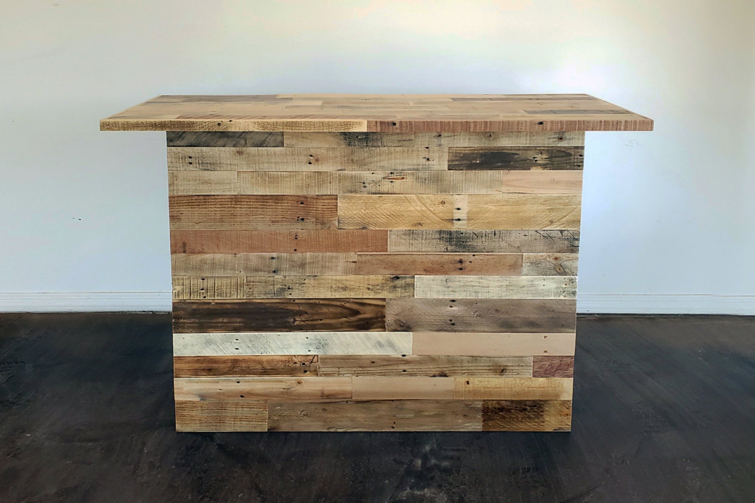 This handcrafted bar-height table, made in Arizona from sustainably sourced reclaimed wood, showcases a rustic patchwork design—perfect as a kitchen island or restaurant table—highlighting lasting quality and eco-friendly style.