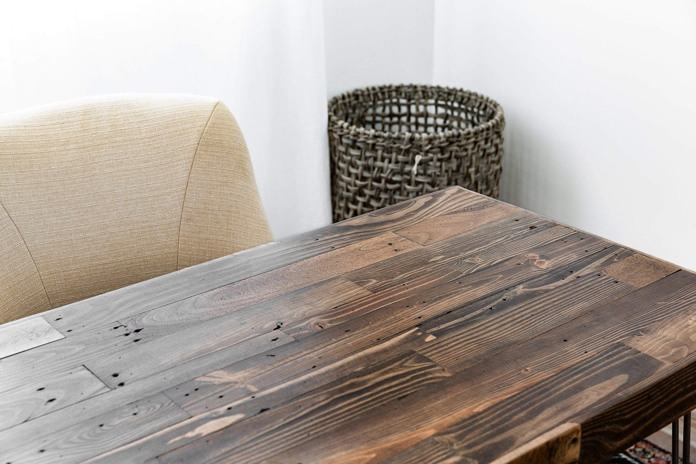 Experience the enduring quality of our handcrafted reclaimed wood desk, thoughtfully paired with a beige upholstered chair. This narrow reclaimed wood furniture piece brings sustainable craftsmanship to your home or office workspace.