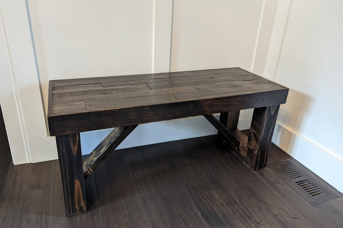 This handcrafted reclaimed wood farmhouse bench showcases timeless craftsmanship, with sturdy angled supports and a rustic finish. Ideal as a narrow dining table, restaurant table, or entryway bench. Built to last with eco-friendly materials.