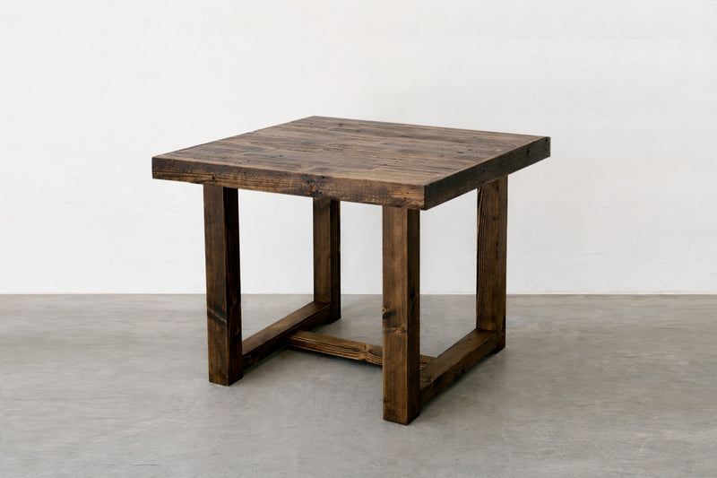 This handcrafted, square dining table features a dark reclaimed wood finish and sturdy straight legs, highlighting visible grain for timeless appeal. Ideal as a counter-height or restaurant table, expertly made in Arizona.