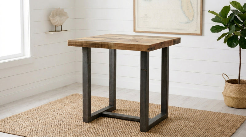This artisan-crafted dining table features a thick, reclaimed wood top and sturdy black steel legs, creating an inviting centerpiece for any kitchen or restaurant. Ideal as a counter-height table or narrow bar table.