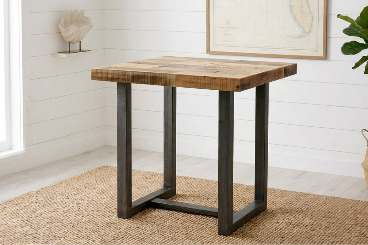 Experience timeless craftsmanship with this handcrafted bar-height table, featuring a thick reclaimed wood top and sleek black steel legs. Ideal as a narrow dining table or kitchen island, it exudes modern coastal charm.