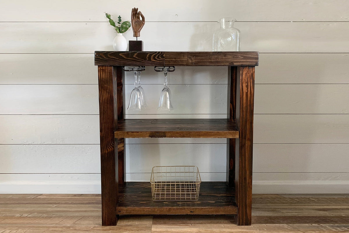 Expertly crafted in Arizona, this reclaimed wood bar cart showcases artisanal quality with two spacious shelves, a wire basket, and elegant décor accents—a unique reclaimed wood furniture piece.