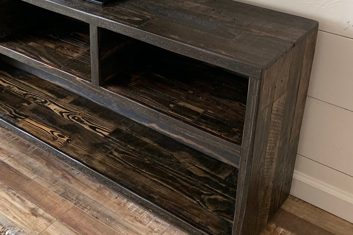 A close-up of a handcrafted, rustic vinyl record console showcasing open shelves and enduring quality, made from sustainably sourced reclaimed wood.