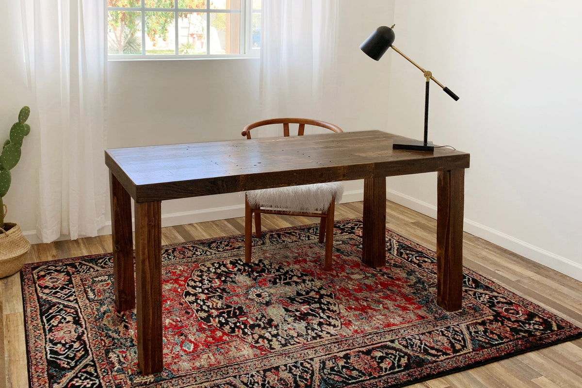 Experience the warmth of handcrafted reclaimed wood furniture with this sustainably sourced wood desk, paired with a chair and black lamp—an ideal work table for home office or workspace versatility.