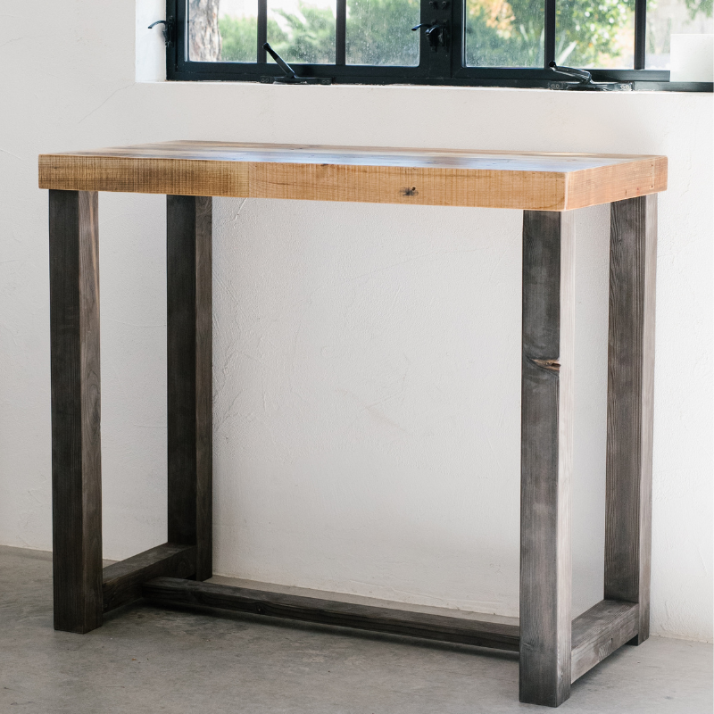 Image of bar height table in a light, natural finish - handmade by Kase Custom in Phoenix, Arizona - set in a simple, modern space with concrete flooring, white walls and black paned windows