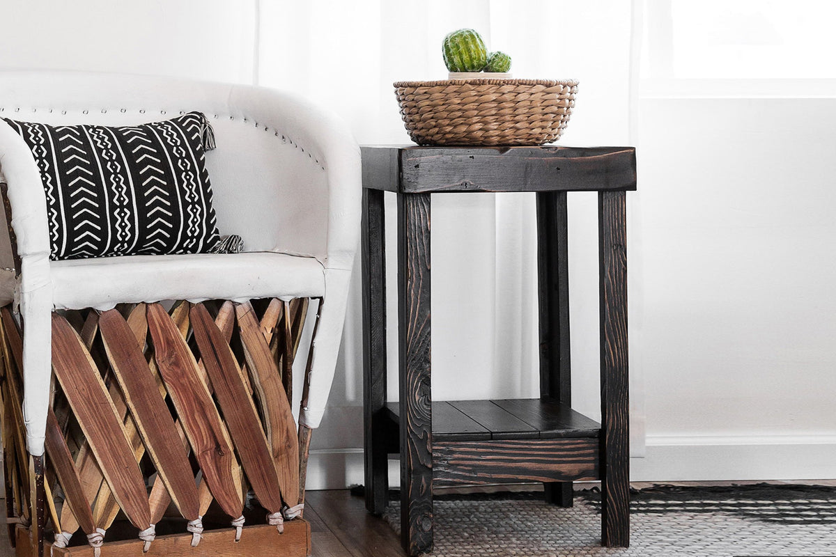 Expertly crafted in Arizona, this bright living room showcases a white upholstered chair and a sustainable reclaimed wood side table, perfect as a narrow dining table or accent piece. Handwoven basket and green plant add warmth.