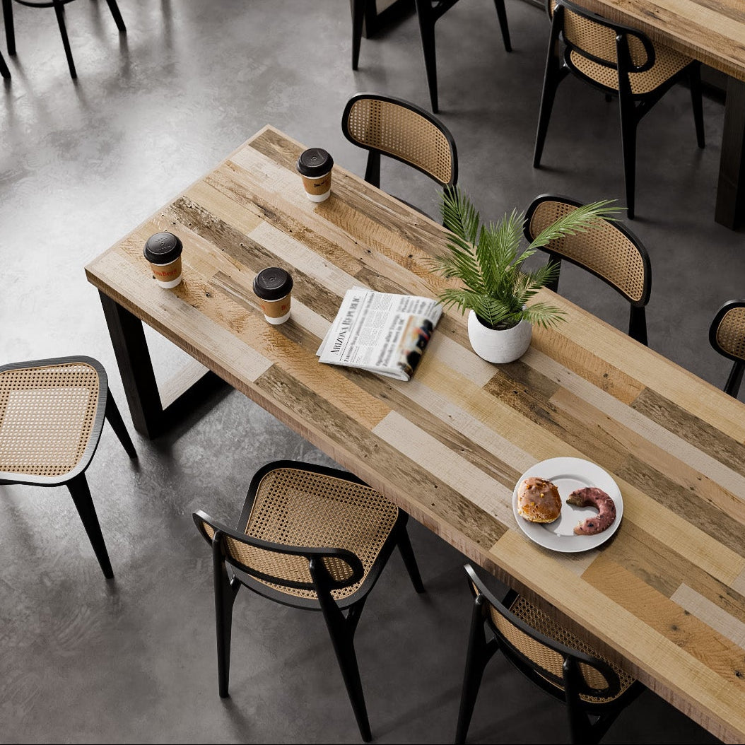 Inviting cafe featuring reclaimed wood dining tables, sleek black chairs, and plush brown bench seating. Sunlit windows and handcrafted decor highlight enduring quality. Potted plants, books, and cups add warmth to this restaurant table setting.