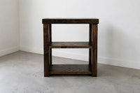 Espresso finish custom solid wood coffee bar on concrete floor in front of white wall. 