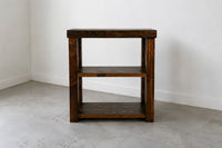Provincial finish solid wood coffee bar on concrete floor in front of white wall. 