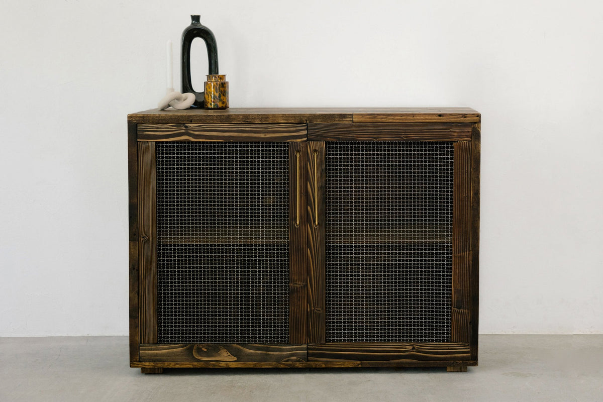 Experience timeless design with this handcrafted reclaimed wood sideboard, featuring two mesh-front doors. This sustainable furniture piece offers lasting quality and artisan detail.
