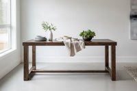 Discover our Arizona-handcrafted bar-height table, crafted from sustainable reclaimed wood. Accented with a beige runner, elegant dishware, and greenery, this narrow counter-height table elevates any modern dining or restaurant space.