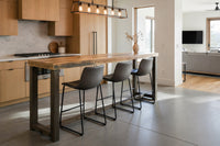 Modern kitchen island made from reclaimed wood with leather stools,  open-plan living area.