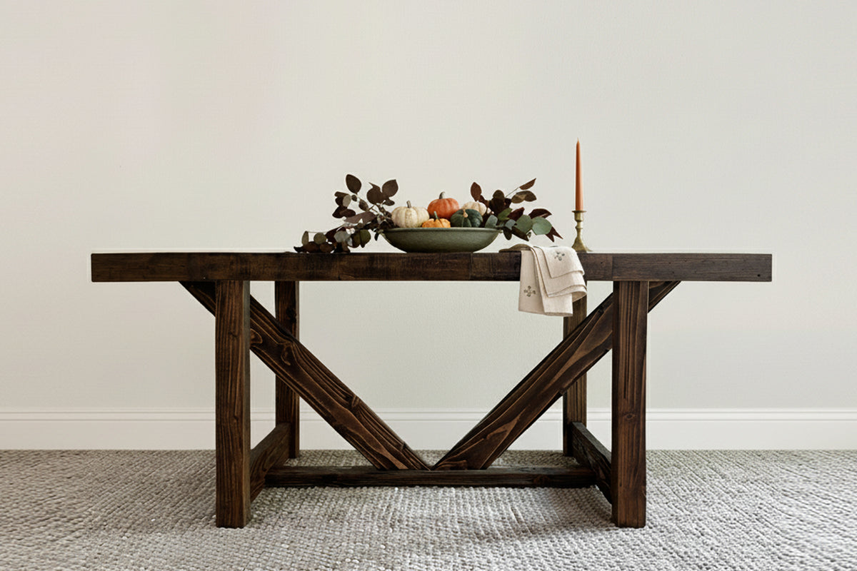 This handcrafted reclaimed wood dining table showcases sustainable craftsmanship, featuring a festive centerpiece and warm candlelight. It offers enduring quality and timeless design.