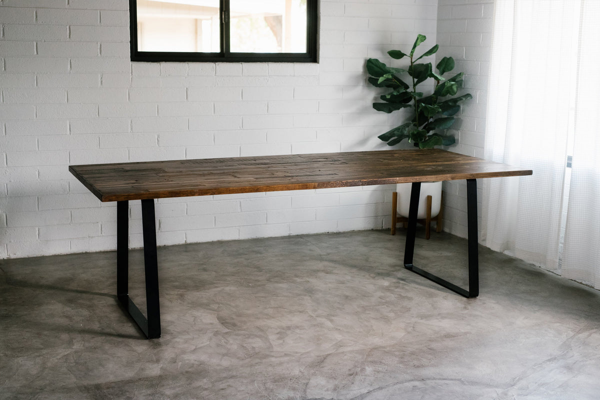 This handcrafted, Arizona-made reclaimed wood dining table features sturdy black steel legs and a sleek, narrow silhouette.