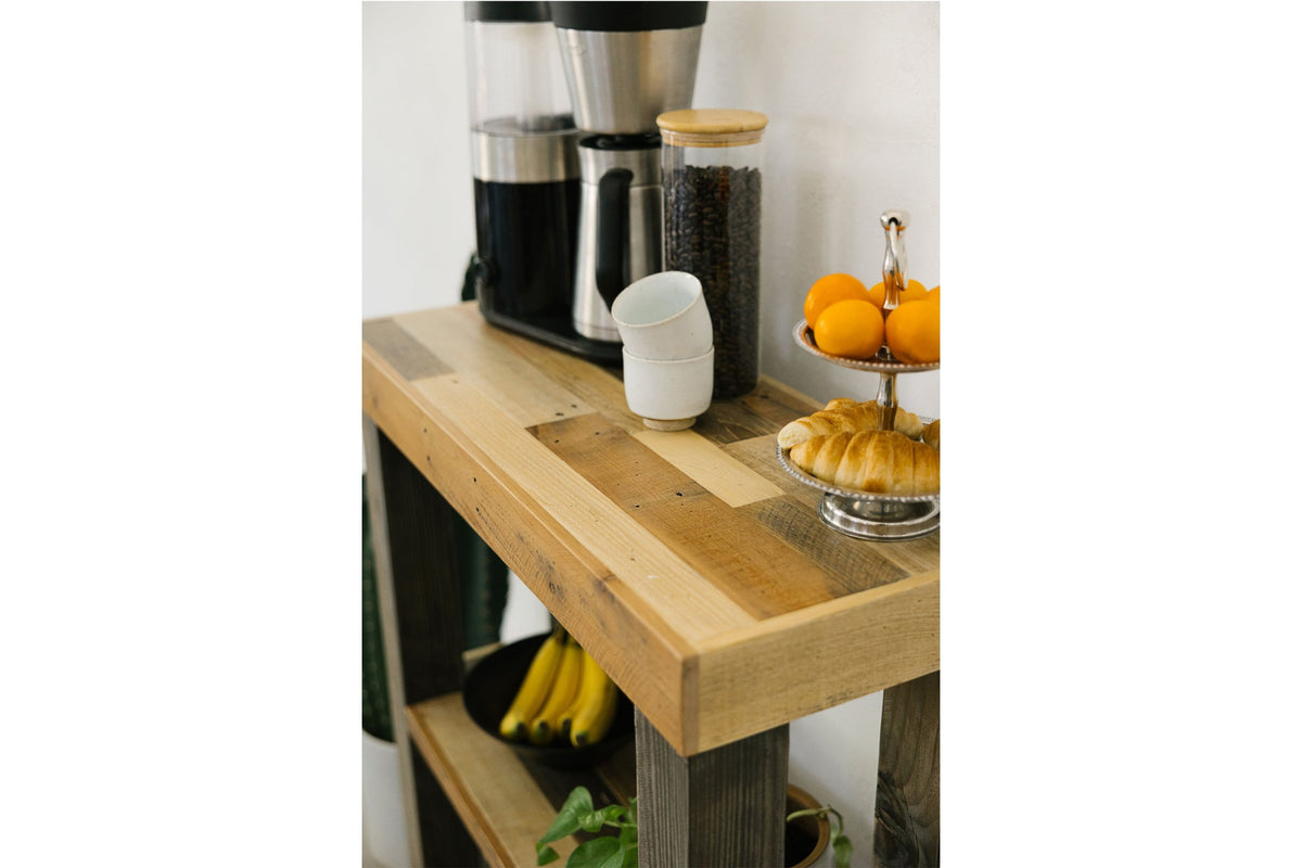 This handcrafted reclaimed wood coffee bar station exudes enduring quality, showcasing premium sustainable materials. Perfect coffee station for small kitchen, it displays a coffee maker, beans, fruit, and pastries with style.