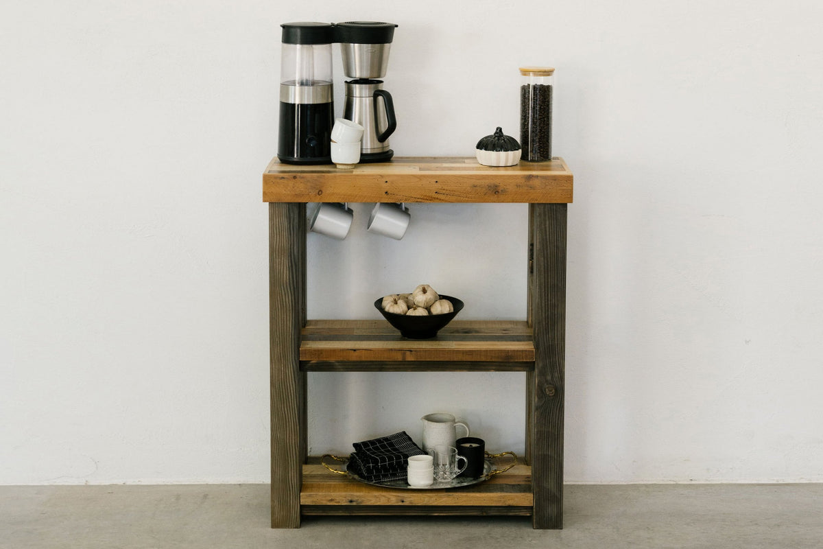 This handcrafted coffee station is custom made with reclaimed wood and sustainable materials. Thoughtful shelves hold a coffee maker, grinder, mugs, and jars.
