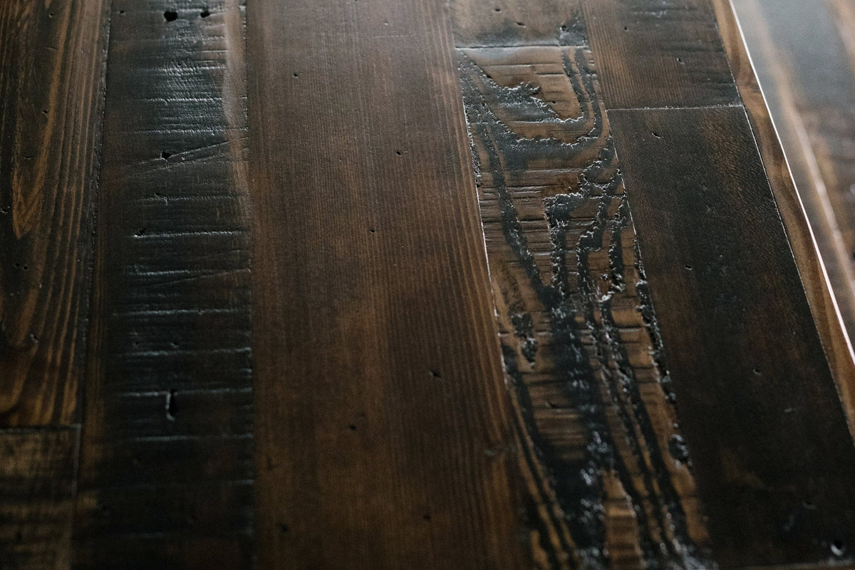 Close-up of a handcrafted reclaimed wood dining table, showcasing rich grain and natural textures with characterful marks. Sustainable furniture, artisan-made in Arizona.