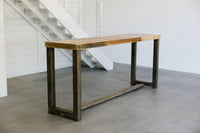 This handcrafted reclaimed wood bar-height table, made in Arizona, features a rectangular top and robust dark legs—perfect as a narrow dining table, kitchen island, or restaurant table in modern industrial spaces.