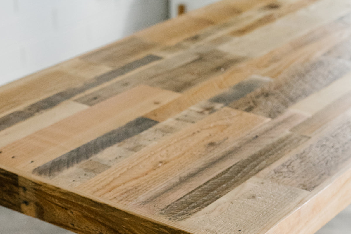 Close-up of a handcrafted reclaimed wood table featuring unique planks in warm, natural tones and rich textures. Sustainably made in Arizona, this rustic furniture piece highlights enduring quality and artisanal craftsmanship.